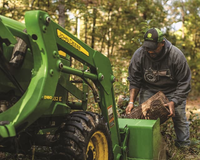A man loads a front-end loader on a 3032E.