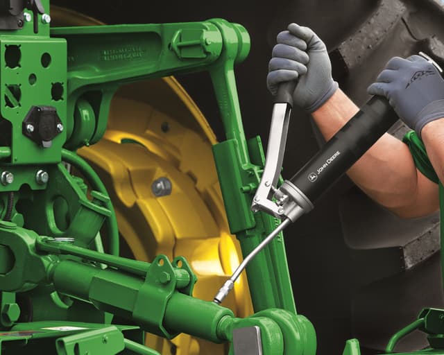 A worker services a John Deere tractor at Tennessee Tractor.