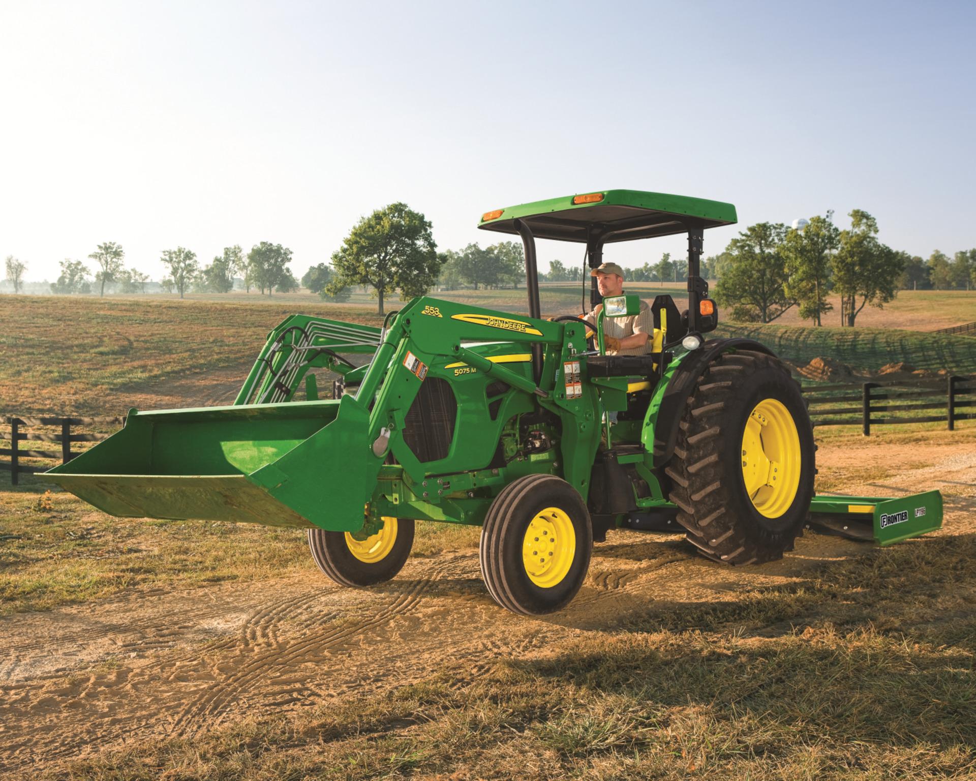 A John Deere 5075M working on a farm.