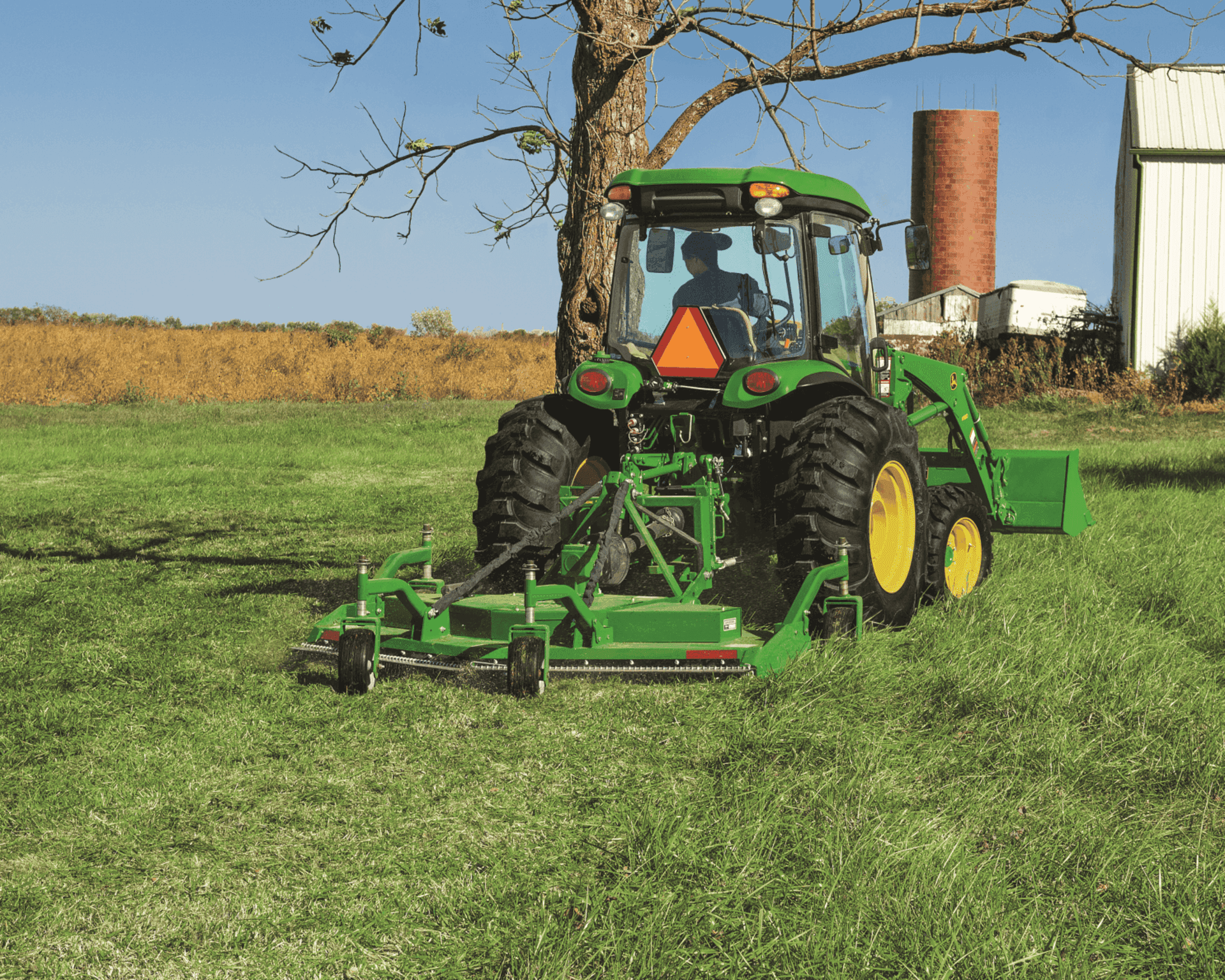 A John Deere 4066R cuts grass on a property.