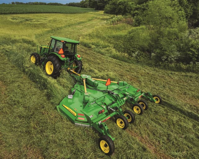 A John Deere tractor pulls a rotary cutter attachment in a field in Tennessee.