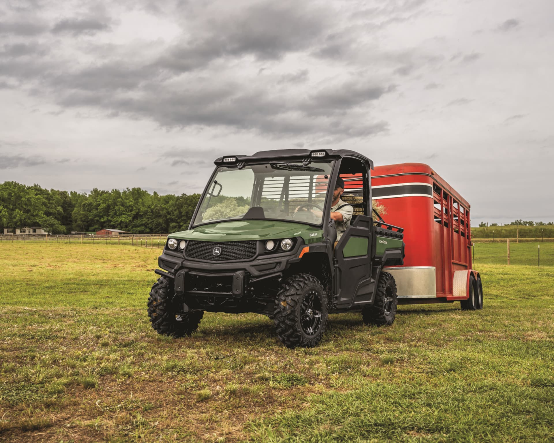 A John Deere Gator pulls a livestock trailer.