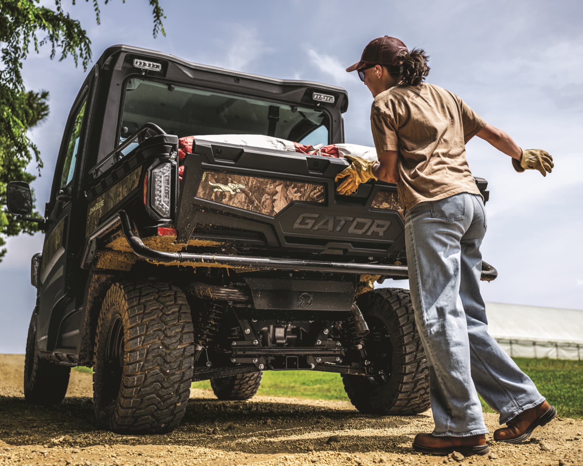 A worker loads a John Deere Gator for a work site.