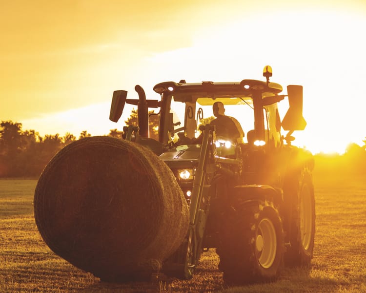 A tractor with a bale spear attachment moves a hay bale in Tennessee.