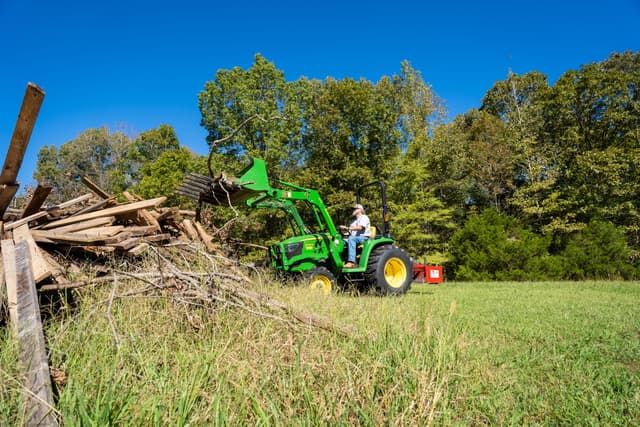 TNTR water well 5 A property owner uses a compact tractor with a front-end loader to remove debris from a future water well site.