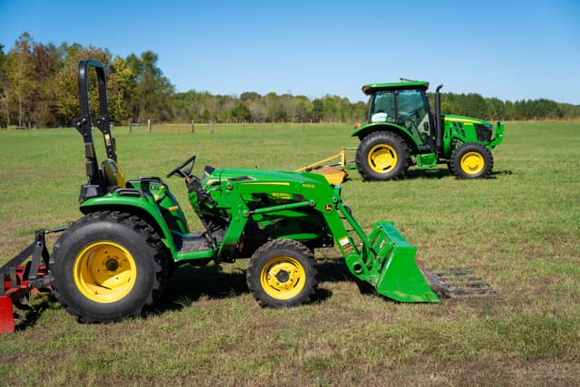 john deere tractors Two John Deere compact tractors sit in a field in Tennessee.