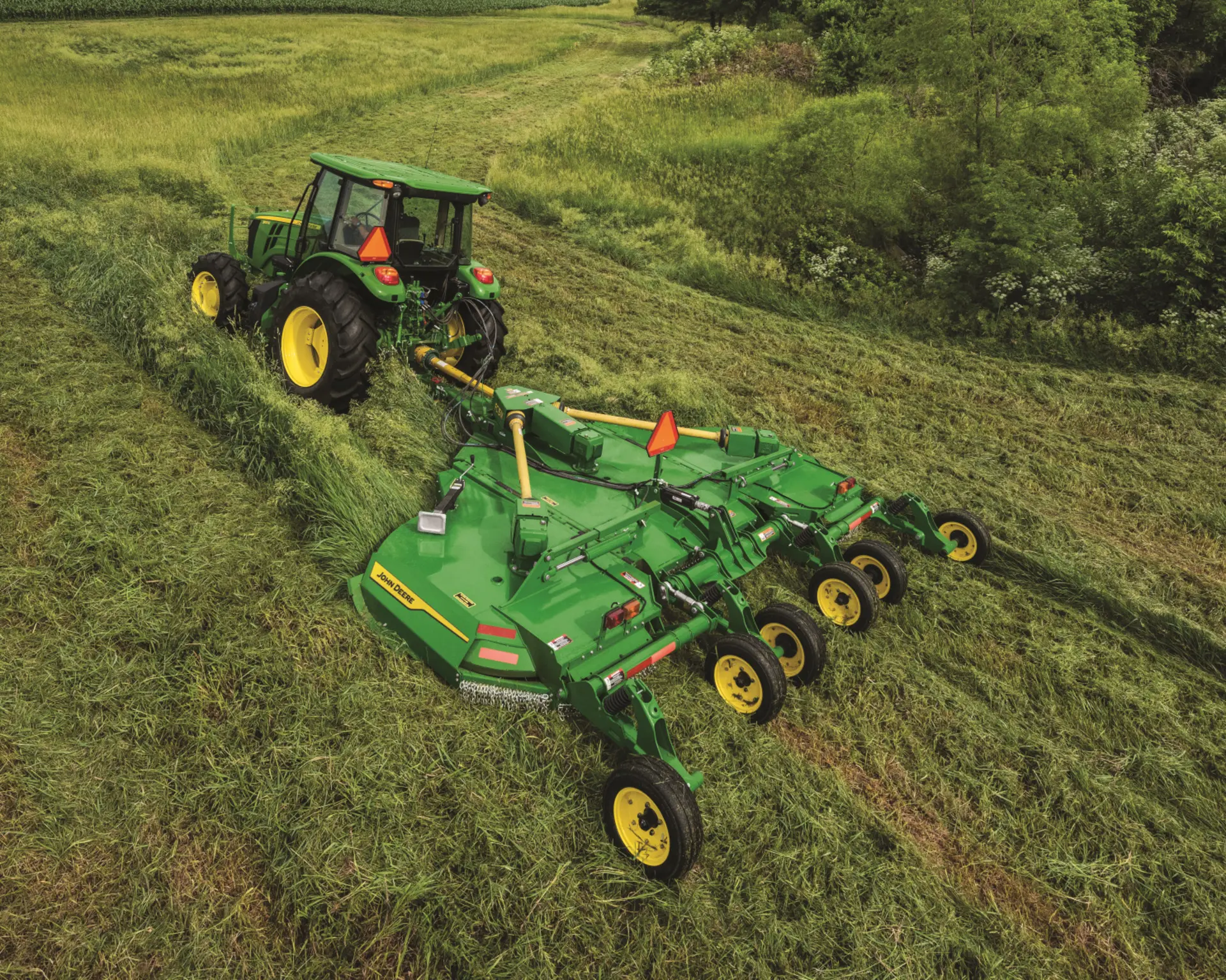 A John Deere 5 Series Tractor with a rotary cutter attachment mows grass in Tennessee.