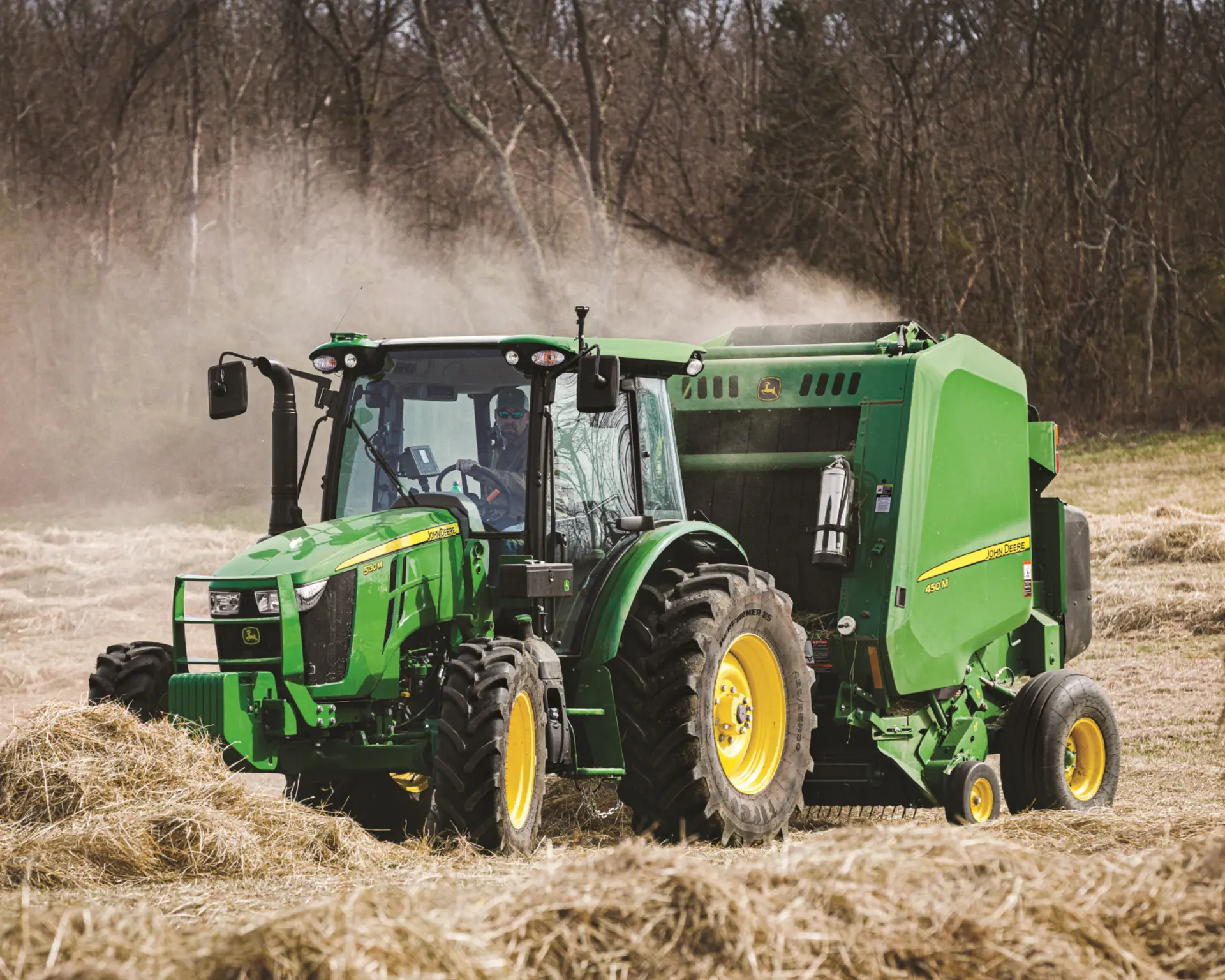 A John Deere tractor with a hay baler bales hay in Tennessee.