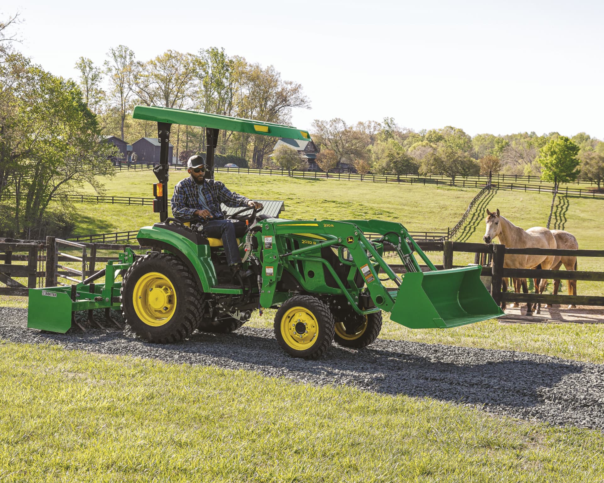 A property owner uses a CUT with a box blade and front-end loader to clear a fence line.