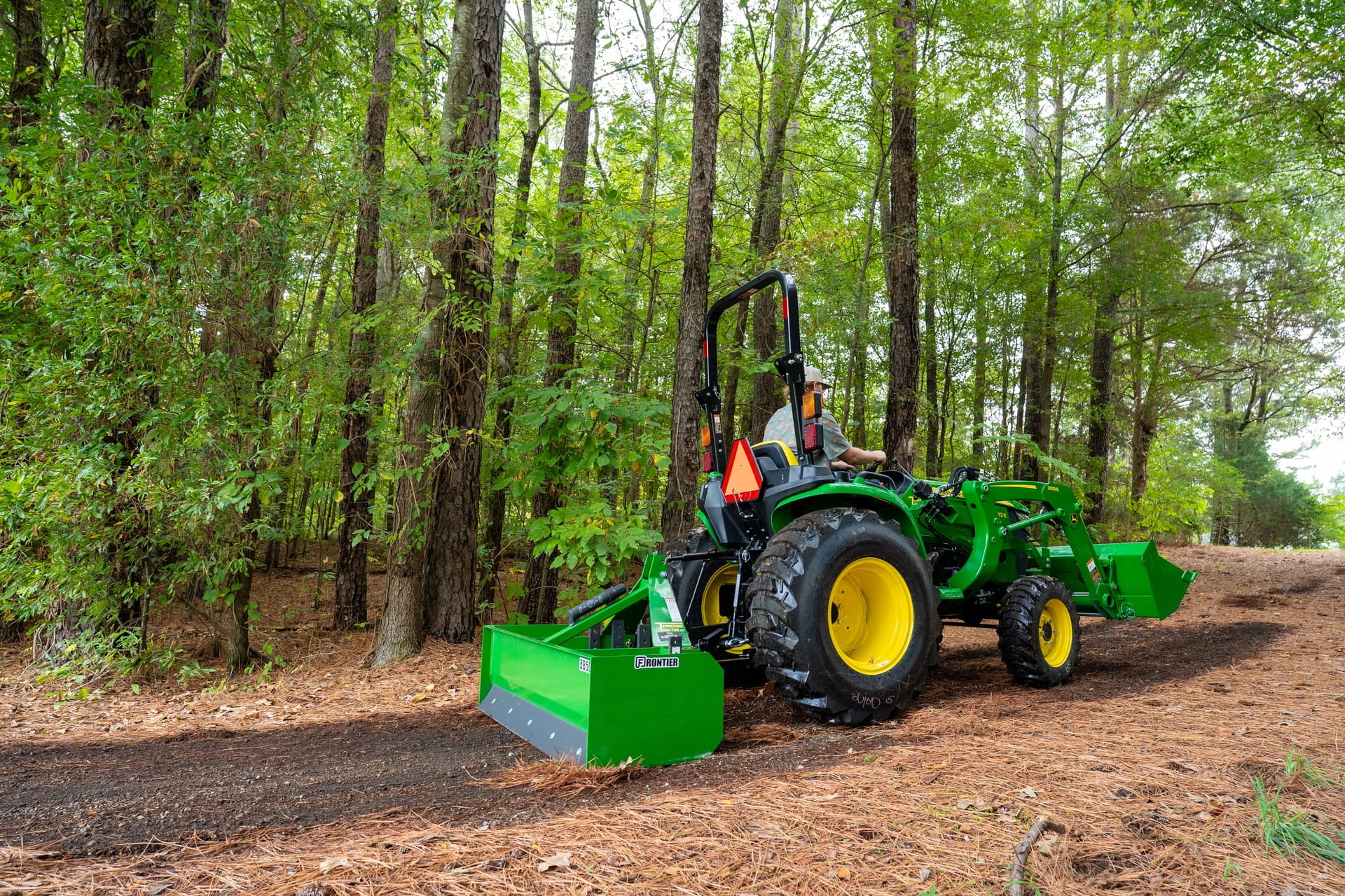 A compact tractor with a box blade prepares land for a water well.