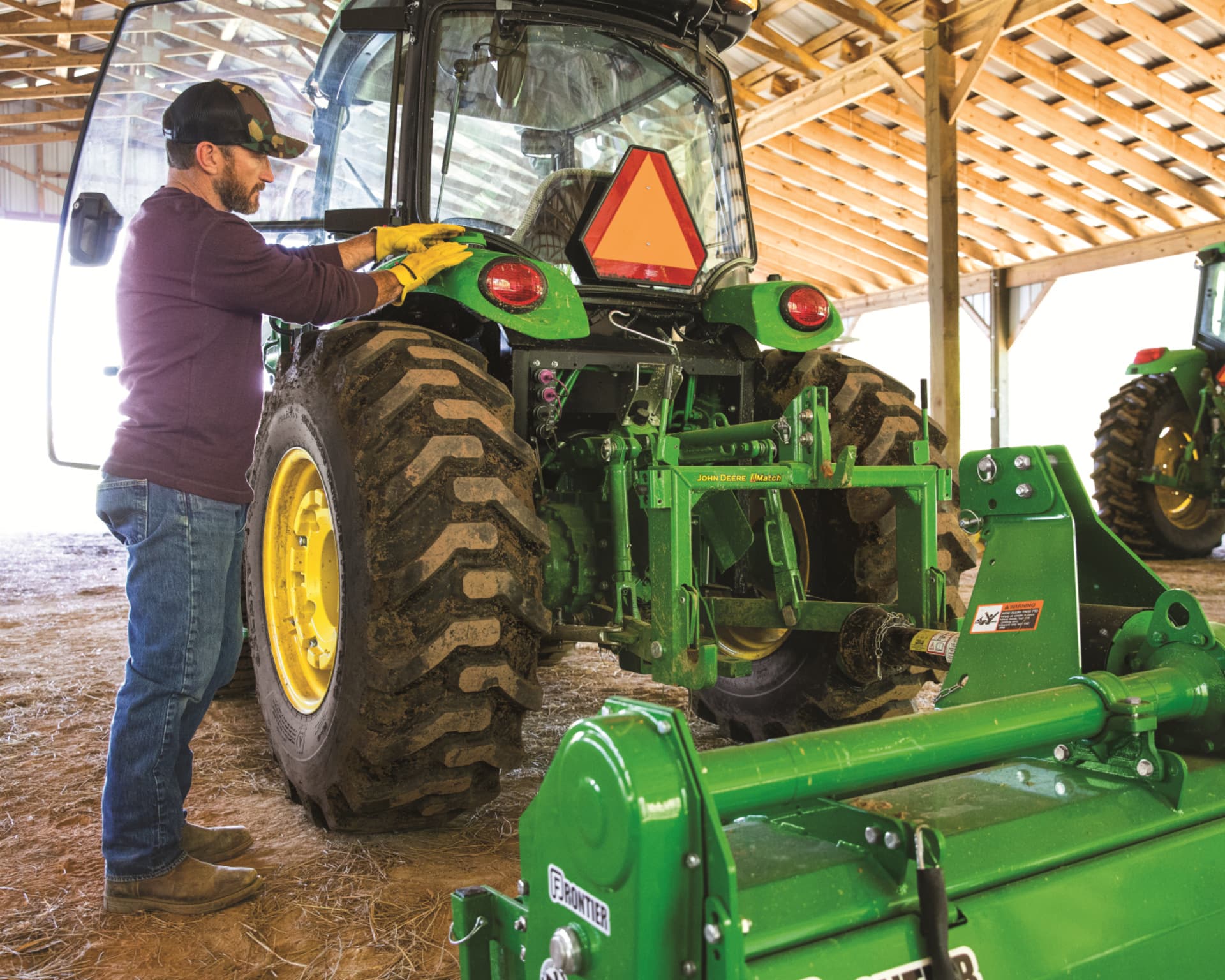 A worker inspects his John Deere tractor on a farm in Tennessee.
