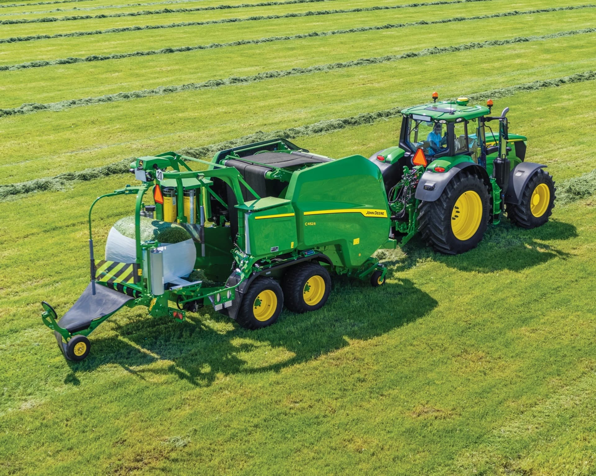 A John Deere tractor pulls a John Deere baler in a field in West Tennessee.