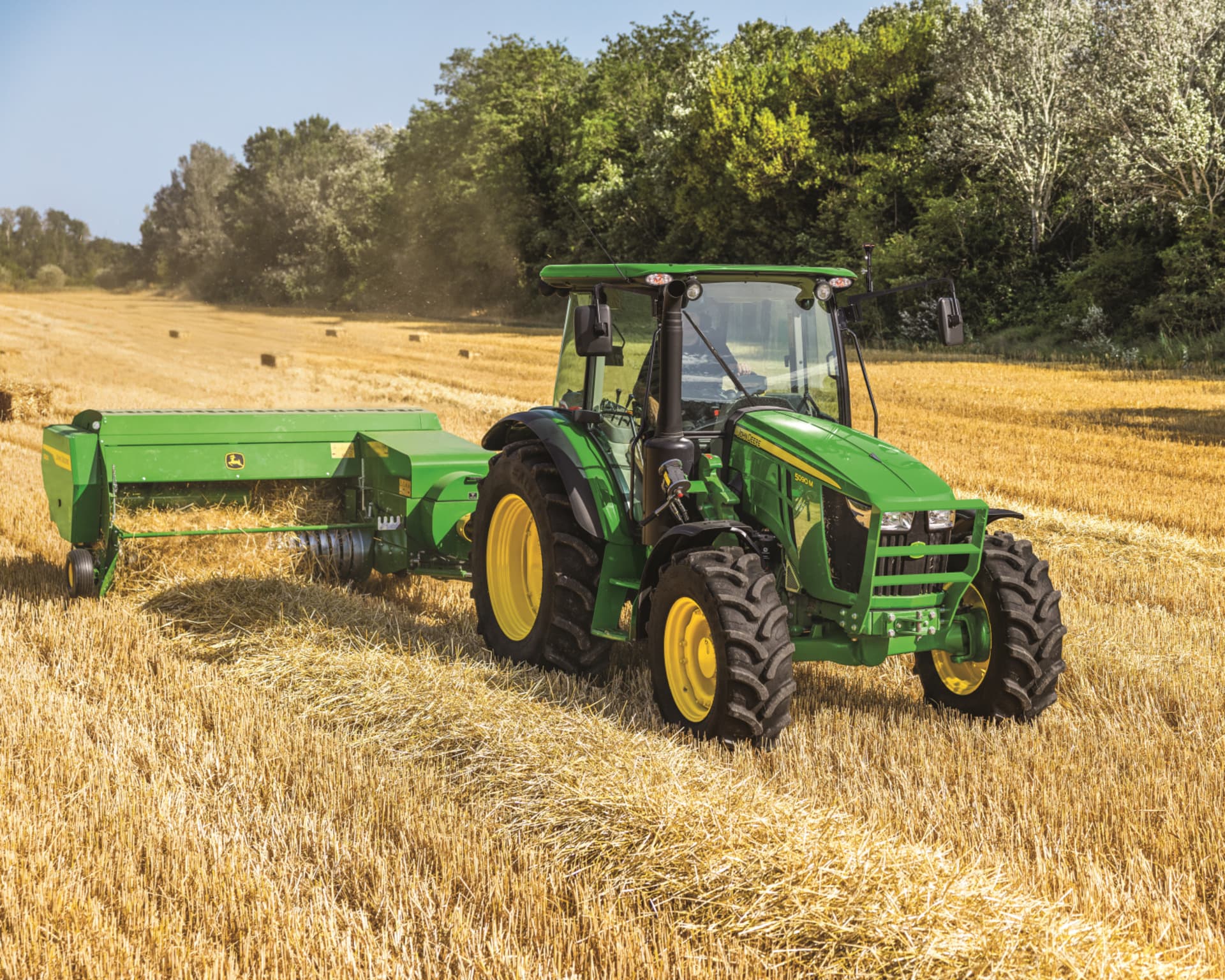 A John Deere tractor pulls hay equipment in a field in Tennessee.